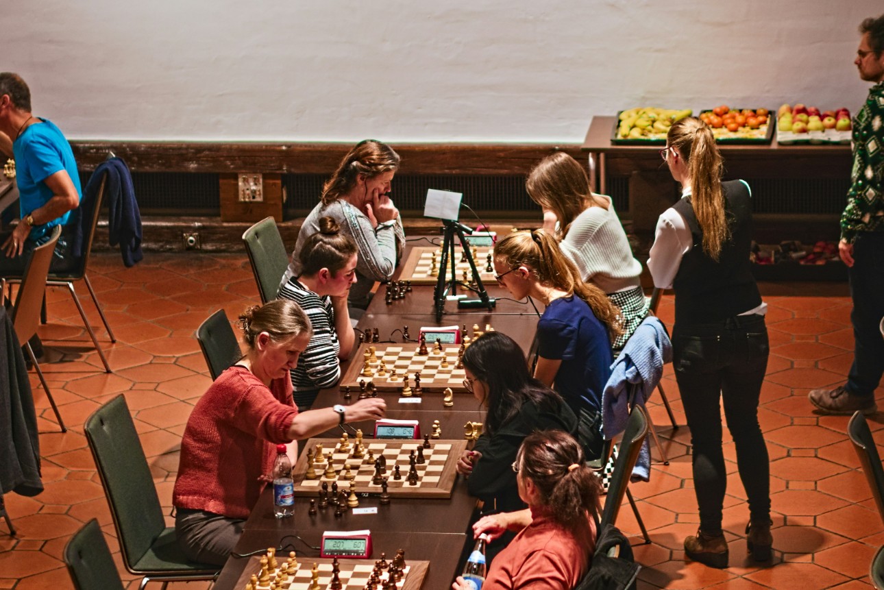 Women playing chess indoors